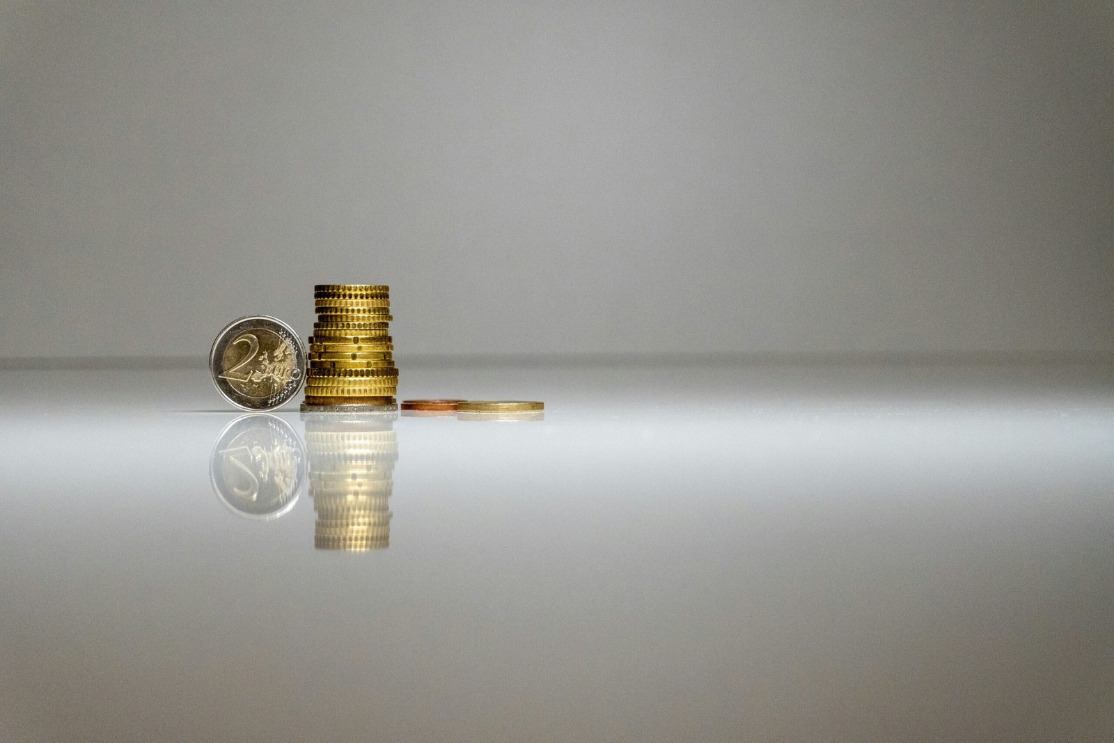 a stack of coins sitting on top of a reflective surface